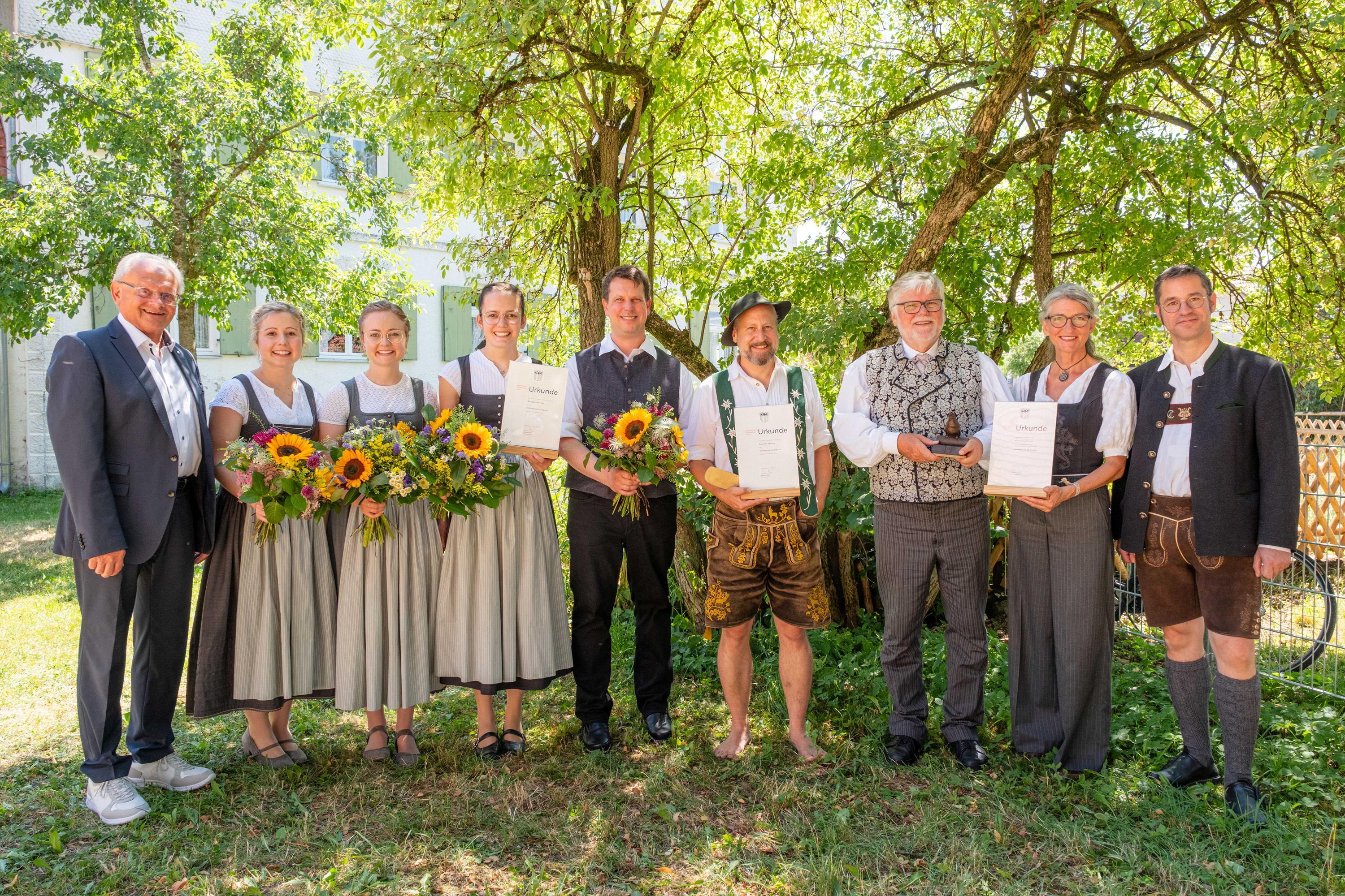 Die Preisträgerinnen und Preisträger des Volksmusikpreises 2026 wurden beim Tag der Volksmusik im Freilichtmuseum Illerbeuren prämiert. Auf dem Bild von links: Stellvertretender Bezirkstagspräsident Alfons Weber, die Burgglöckler Fehla Sophie Eberle, Theresa Schneider und Alexandra Althaus, das Duo Schatzhauser, bestehend aus Hans-Peter Willer und Christian Ludwig Mayer sowie der Preisträger der Schwäbischen Nachtigall, Uwe Rachuth. Daneben von der Volksmusikberatung des Bezirks Schwaben: Evi Heigl und Christoph Lambertz.
Bildnachweis: Foto: Gregor Hanewacker